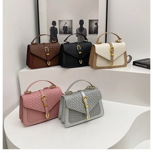 Detailed view of woven flap handbags in brown, beige, pink, and silver with gold buckles
