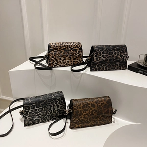Eleganti borse a spalla leopardate in quattro colori su espositore bianco minimalista