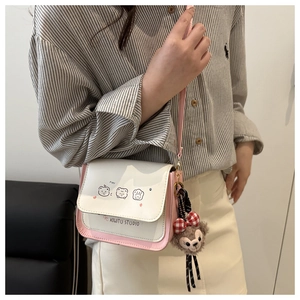 Detail of pink and white crossbody bag with cute animal patterns and plush bear charm