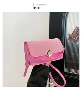 Détail du sac à main rose contrasté avec fermoir doré et texture de tissu sur le rabat