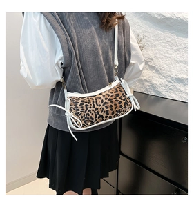 Close-up of leopard print shoulder bag with white bow detail and gold hardware zipper