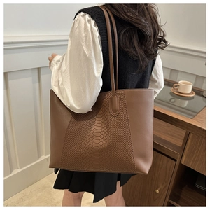 Detailed back view of a brown crocodile pattern tote bag shown in a lifestyle setting