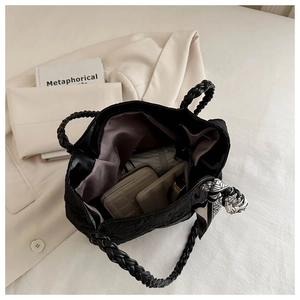Macro view of textured black tote bag interior showing spacious storage and silk scarf detail
