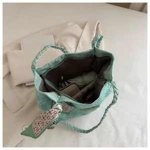 Detail view of large mint green tote bag interior with floral embroidery and silk scarf