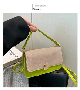 Détail du sac à main vert et beige avec texture tissée et boucle en métal doré