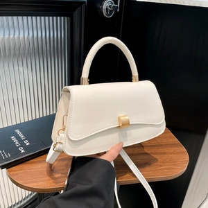 Minimalist white leather crossbody bag with gold metal buckle and round top handle