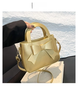 Dettaglio del fiocco dorato e della chiusura metallica sulla mini borsa a mano elegante