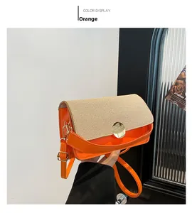 Détail du sac bandoulière en similicuir orange avec rabat tissé beige et fermoir doré