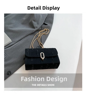 Close-up of textured black denim small square bag with golden chain and metal buckle