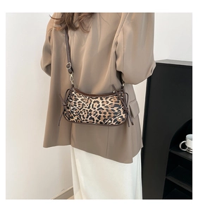 Detail view of leopard print crossbody bag with bow accents and adjustable shoulder strap