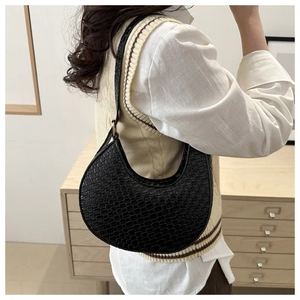 Side view of black faux leather hobo bag with crocodile pattern texture on model