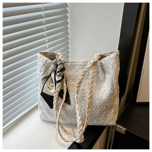 Detail of white jacquard tote bag with sunflower textures and decorative scarf