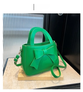Dettaglio della borsa verde con grande fiocco 3D e tracolla con dettagli dorati