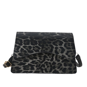 Borsa a spalla leopardata con tracolla nera e dettagli dorati su sfondo bianco