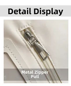 Nahaufnahme eines silbernen Metallreißverschlusses an einer cremeweißen Nylon-Tasche