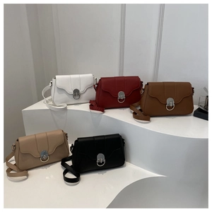 Detailed view of five colorful square crossbody bags with oval metal twist locks