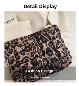 Detail of leopard print quilted clutch showing fine square stitching and soft fabric