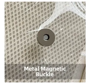 Nahaufnahme eines silbernen Magnetverschlusses auf einer cremefarbenen Netztasche