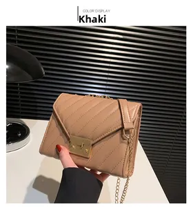 Detailansicht der khakifarbenen Stepptasche mit Kette und goldenem quadratischem Schloss