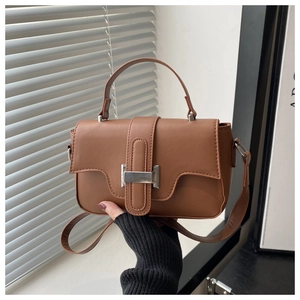 Detailed view of brown PU leather handbag with elegant silver metal lock clasp and handle