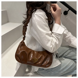 Detail of dark brown ruched shoulder bag with glossy texture and metal logo