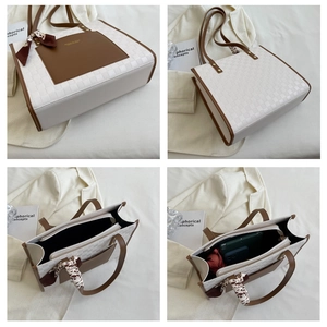 Detail view of cream checkered tote bag with brown handles and internal storage space
