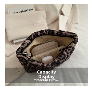 Interior view showing capacity of leopard print quilted clutch with phone and wallet