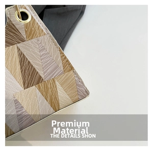 Macro detail of geometric triangle pattern fabric and gold metal eyelet on shoulder bag