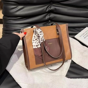 Brown checkered tote bag with dark leather pockets and a leopard print silk scarf detail