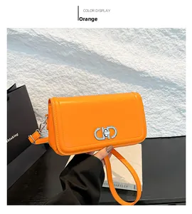 Detail of orange smooth leather crossbody bag with silver interlocking buckle and strap