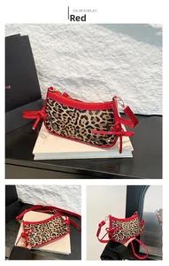 Detail of leopard print handbag with red patent leather trim and bow accents