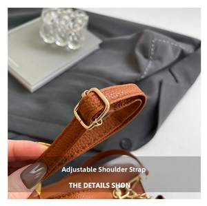 Macro shot of brown pebble leather adjustable strap with gold-tone buckle detailing