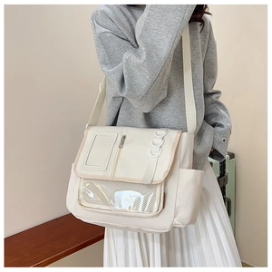 Detailansicht der cremefarbenen Messenger-Bag aus Nylon mit PVC-Fach und Schultergurt