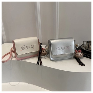 Detail of two mini PU leather crossbody bags with cute animal prints and furry charms