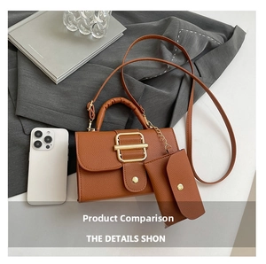 Detail of tan pebble leather square bag with gold buckle and mini envelope coin purse