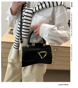 Elegante borsa nera con fibbia a D dorata e tracolla in pelle regolabile