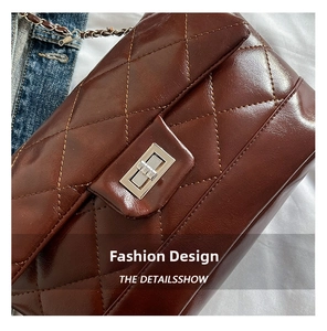 Detail of dark brown quilted faux leather bag with silver metal turn-lock and chain strap