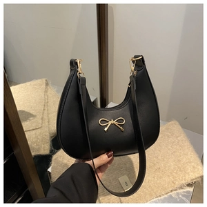 Detail shot of black crescent shoulder bag with golden bow metallic hardware finish