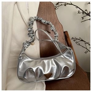 Detail of silver ruched handbag showing metallic pleated texture and triangle metal plaque