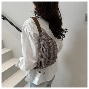 Detail of vintage plaid crossbody bag featuring adjustable strap and premium zipper