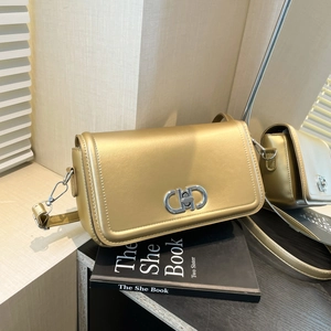 Metallic gold leather shoulder bag with circular silver buckle and adjustable strap