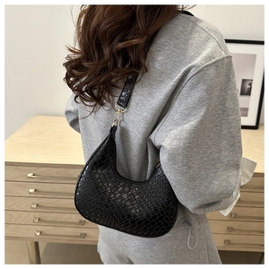 Detailed view of black crocodile pattern faux leather crescent shoulder bag with gold hardware