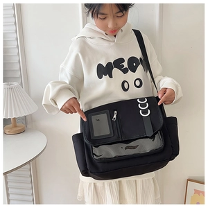 Detailansicht einer schwarzen Canvas-Umhängetasche mit transparentem PVC-Boden und D-Ring-Dekor