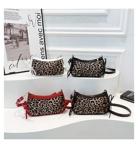 Detailed display of leopard print crescent bags with metal rivets and ribbon bows