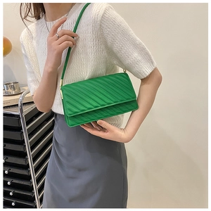 Détail du sac bandoulière en cuir vert avec texture sophistiquée de coutures matelassées