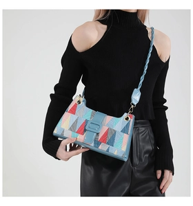 Detail of colorful geometric patchwork bag with woven blue strap on a model