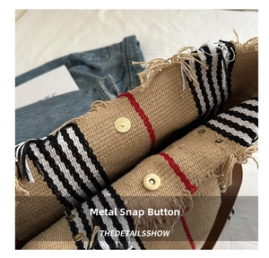 Close-up of the metal magnetic buckle closure on a striped canvas tote bag