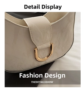 Detail of white marble textured leather handbag featuring polished gold D-shaped buckle