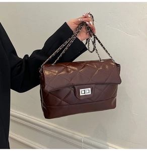 Detail of dark mahogany quilted chain bag featuring silver metallic turn-lock closure