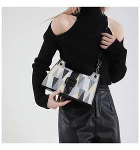 Macro shot of geometric color-block patchwork bag with leather strap and gold hardware